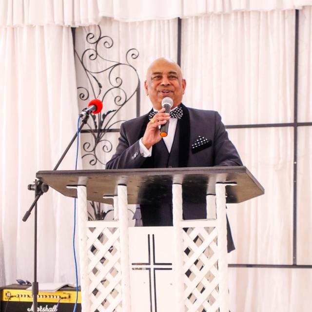 Apostle Harris Govindasamy speaking at a pulpit